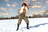 A model in sunglasses, a fur vest, and olive pants stands in snow under a cloudy sky.